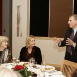 Man speaking to two women at a table